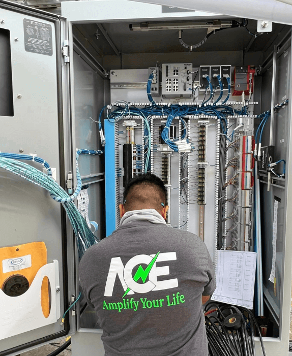 Professional electrician in uniform working on electrical panel with tools, representing Amplify Electric's reliable services.