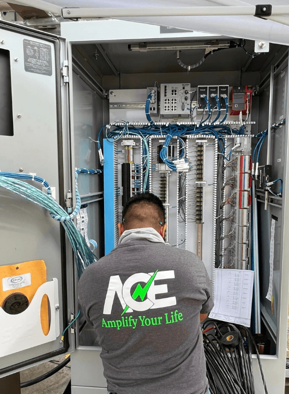 Professional electrician in uniform working on electrical panel with tools, representing Amplify Electric's reliable services.